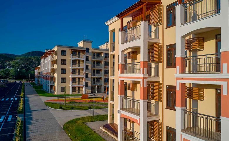 Кипарис — Фасад и балконы вблизи: двухцветная штукатурка и деревянные