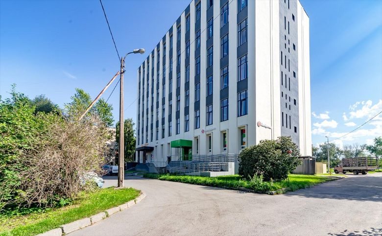 Апарт-комплекс Культ Отважных — Вид с улицы на готовый корпус: виден вход в дом и зелёная вы